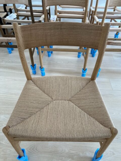 Arv Chair med sæde i håndflettet kuvertflet i papirgarn, opstillet i række.