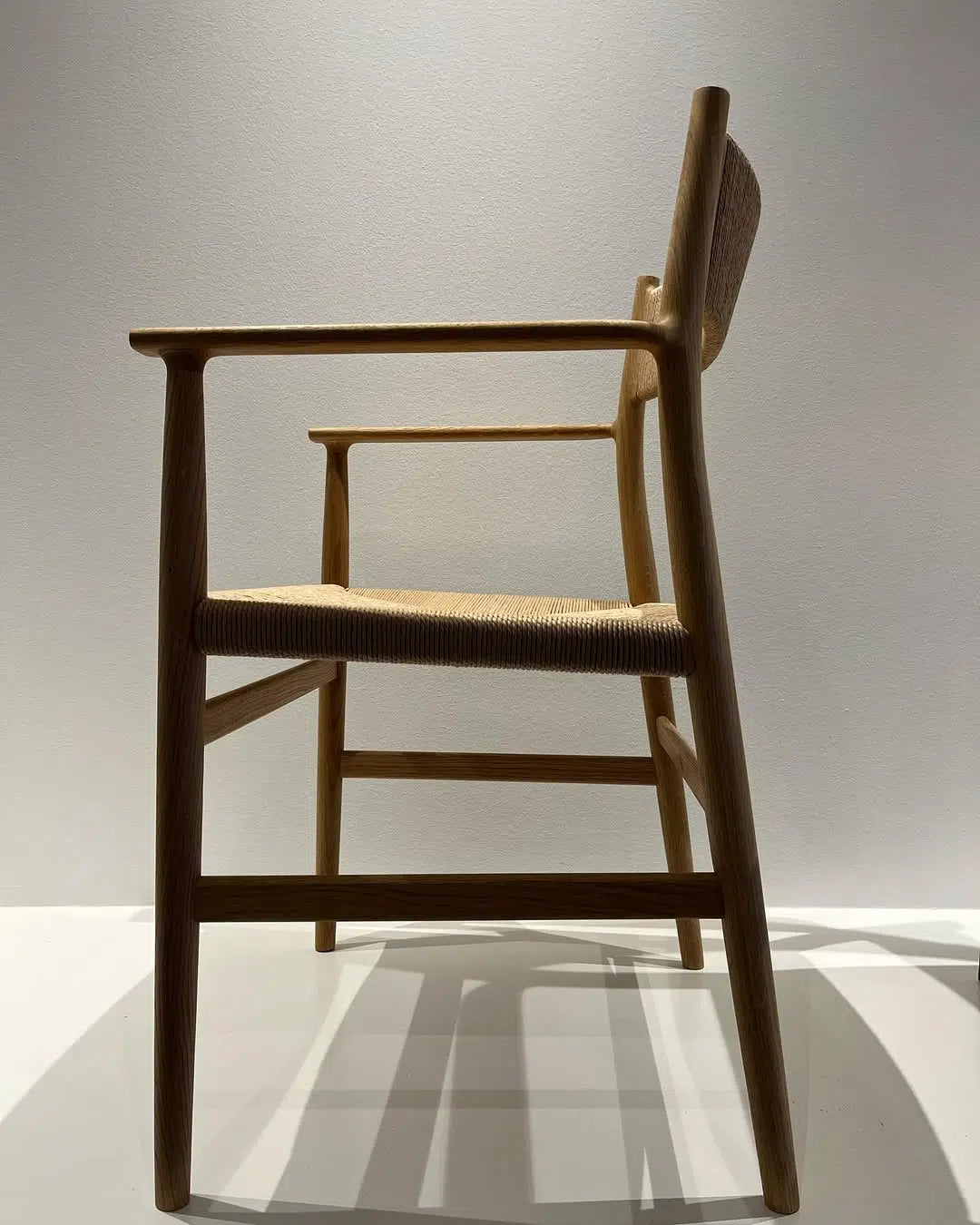 Arv Chair med ryg - kuvertflet i lyst massivt træ set fra siden med fokus på stolens elegante linjer.